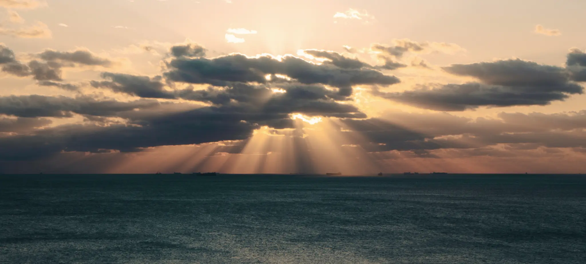 Sunlight breaking through clouds over the sea