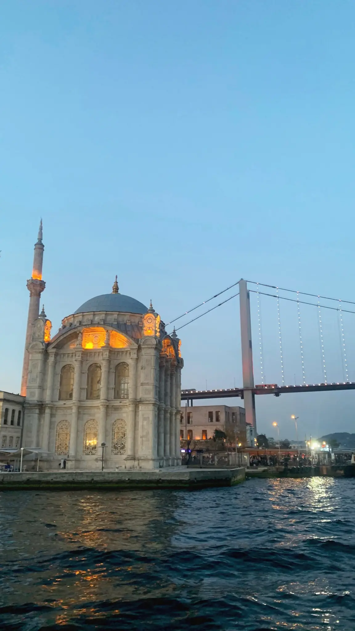 Ortaköy Mosque lit at dusk with the Bosphorus Bridge behind