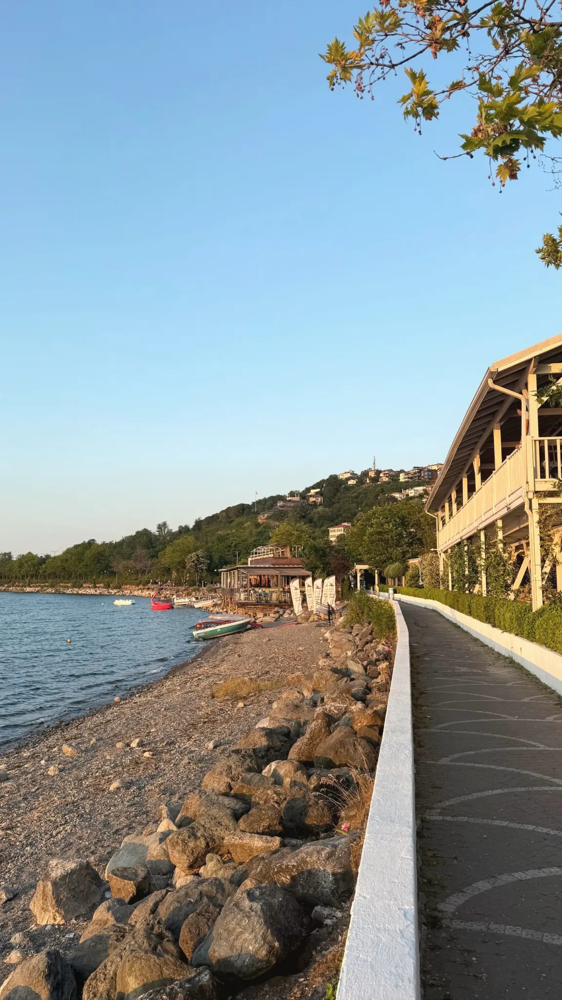 Waterside promenade along a rocky shore in warm evening light