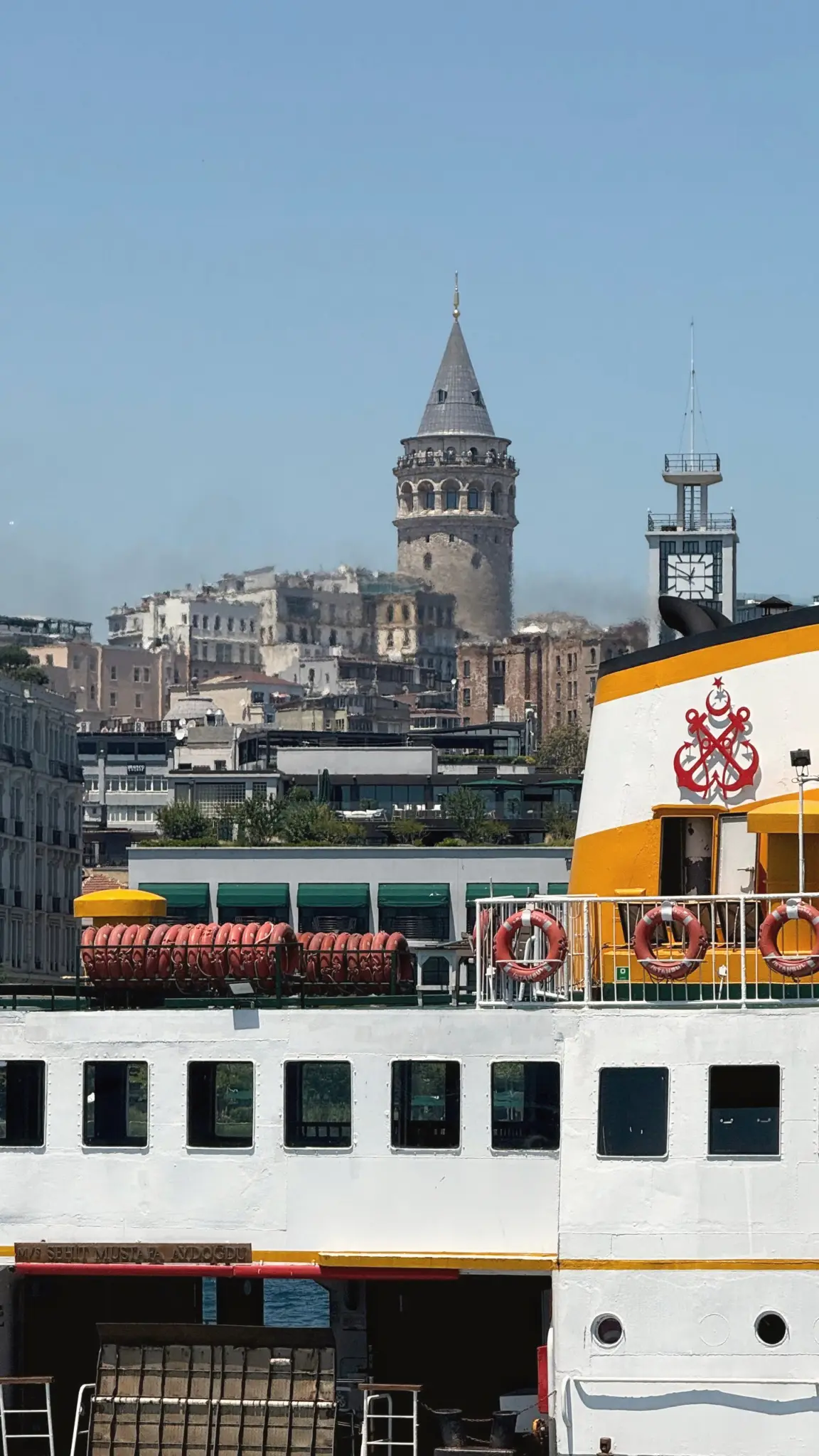 Galata Tower rising over rooftops behind a moored ferry