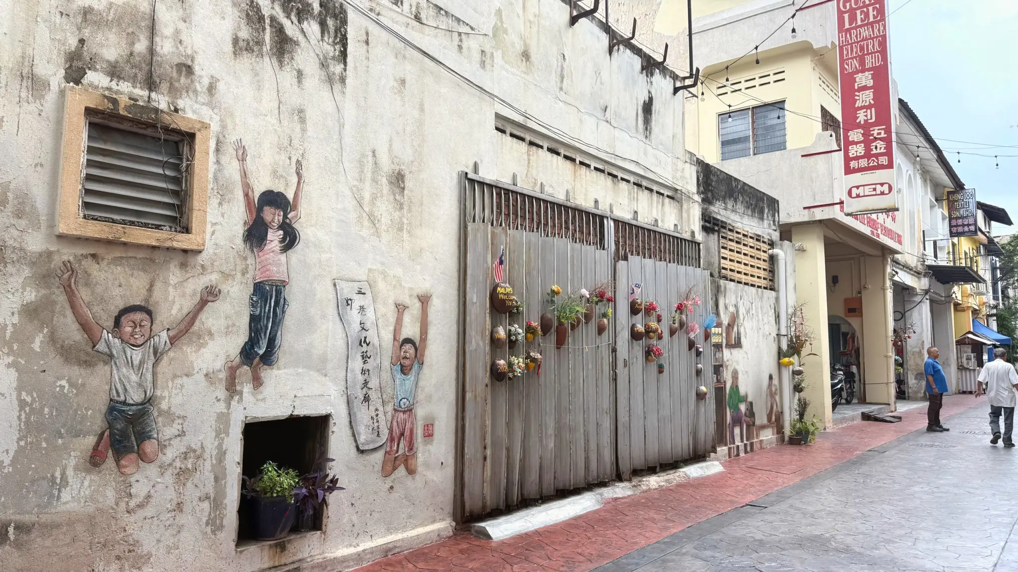 Mural of children playing painted on an old shophouse wall