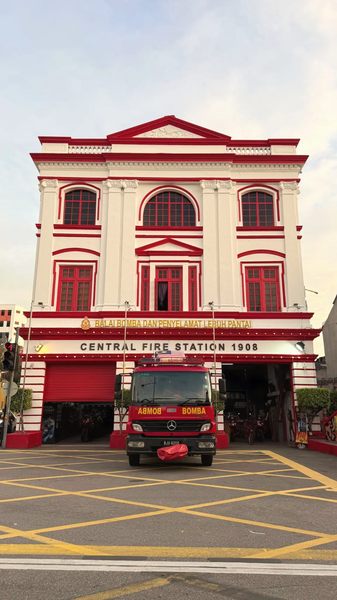 Red and white Central Fire Station 1908 with a fire engine out front